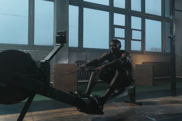 Athlete pulling the handle of an indoor rowing machine