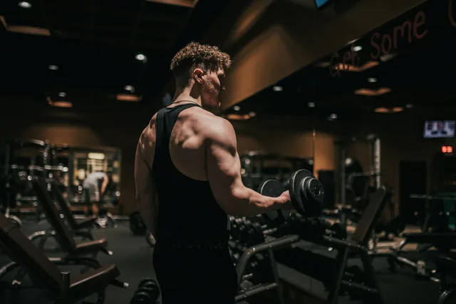 A man lifting a dumbbell in a gym